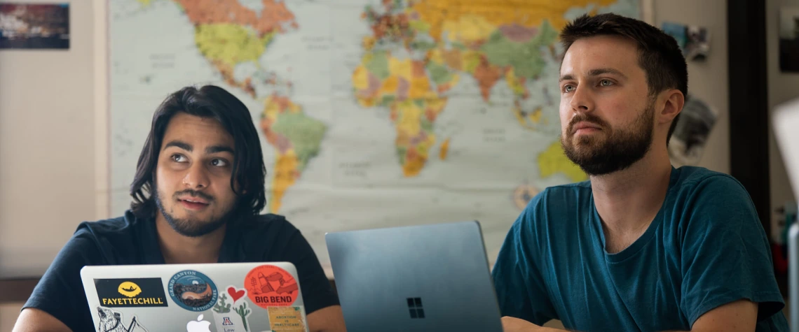 Two students in class with laptops