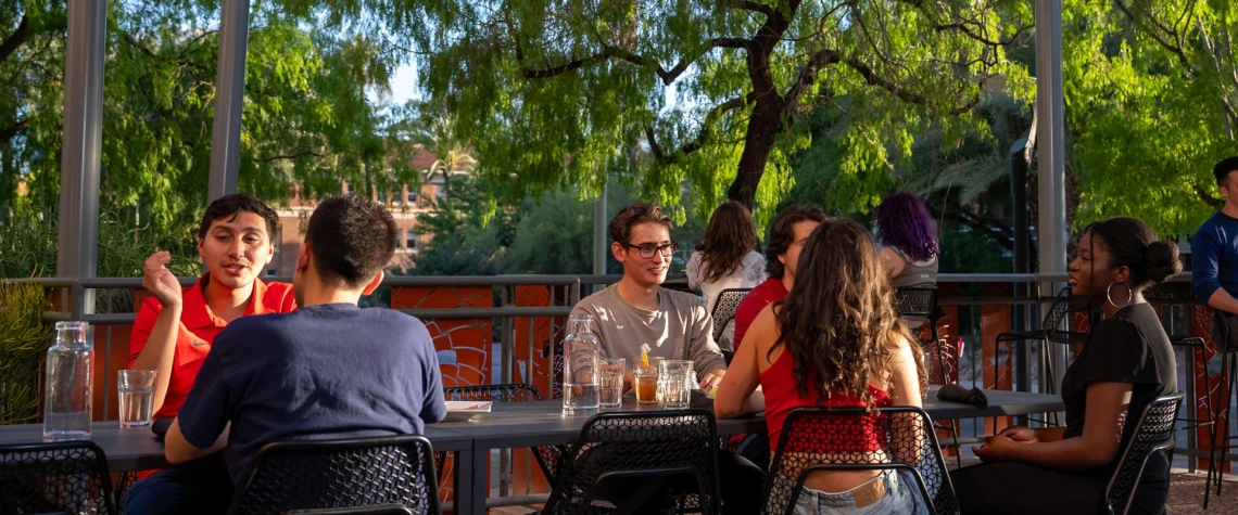 Student sitting at outdoor dining tables